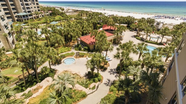 A resort with a pool, palm trees, and a beach view. - Inviting 2 Bedroom Condo in Westwinds at Sandestin Golf and Beach Resort (Miramar Beach)