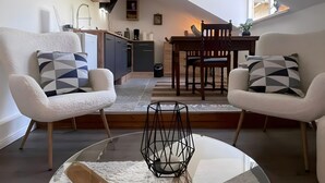 Eine moderne Loftswohnung mit Essbereich, Küche und Sitzgelegenheiten.