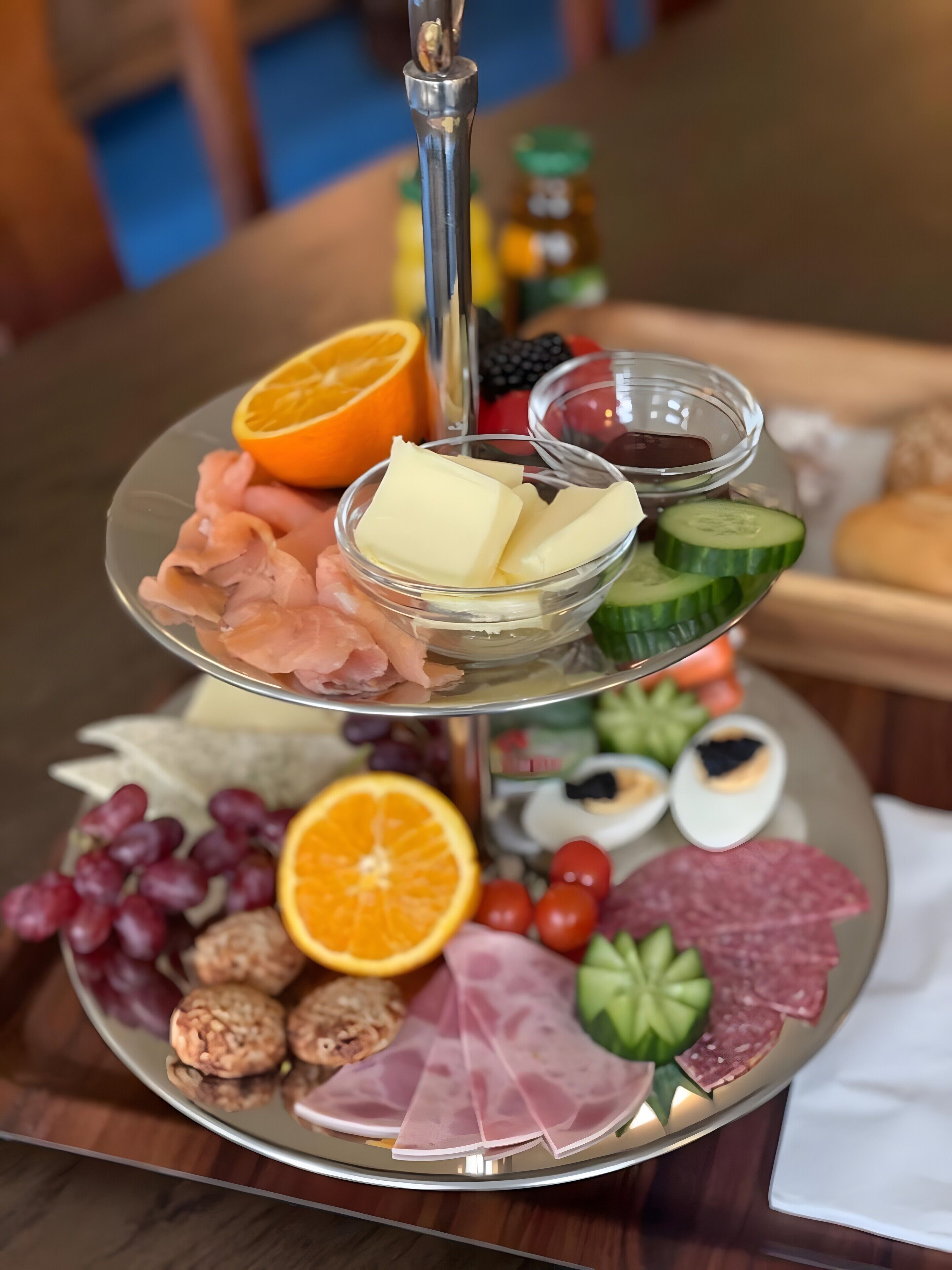 Een etagère met een diverse selectie aan kazen, vleeswaren, fruit en groenten.
