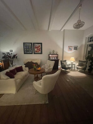 Una sala de estar con sofá, sillones, una mesita de centro y una araña.