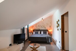 Un dormitorio moderno con una cama grande, un televisor de pantalla plana y una mesa de centro de vidrio.