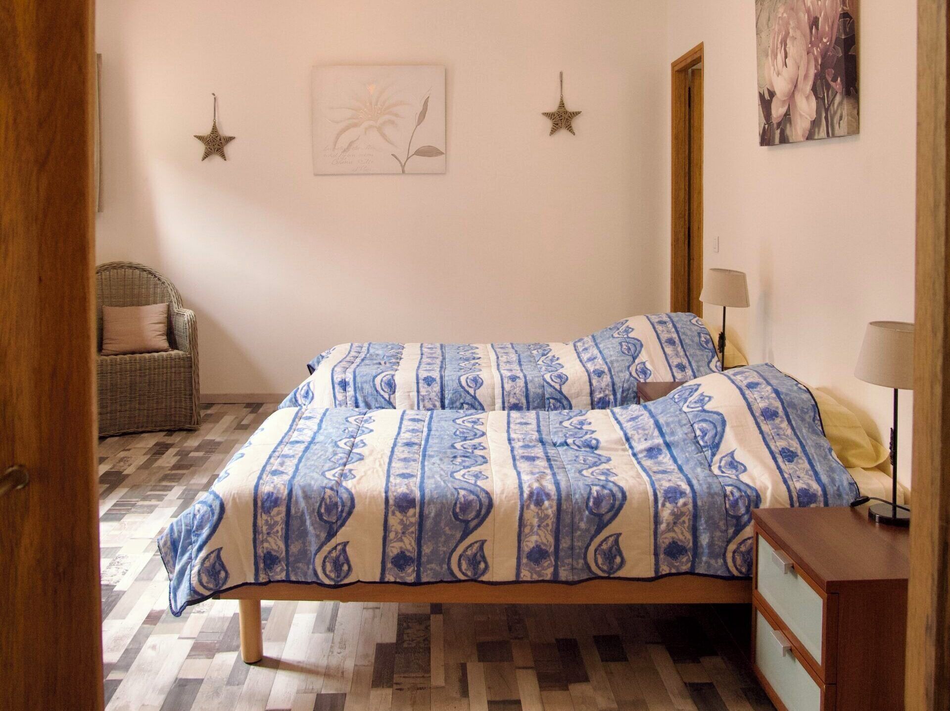 A bedroom with a bed, a chair, a dresser, and wall decorations.