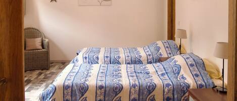 A bedroom with a bed, a chair, a dresser, and wall decorations.