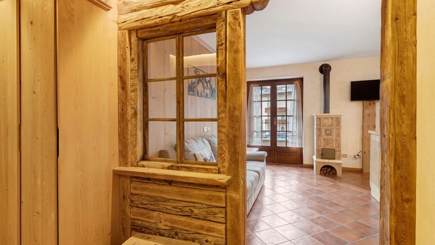 A wooden interior with a bench, a fireplace, and a sofa. - Apartment 'Fior Di Montagna' with Mountain View, Shared Terrace and Wi-Fi (Bormio)