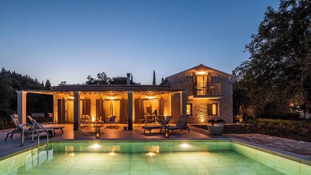 Ein zweistöckiges Haus mit Swimmingpool, Sitzgelegenheiten im Freien und einer überdachten Terrasse.