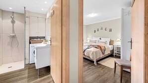 A modern hotel room with a shower, a bed, a desk, and a chair. - Tinkas Kate - Charming bungalow with garden in Westerland, Sylt (Sylt)