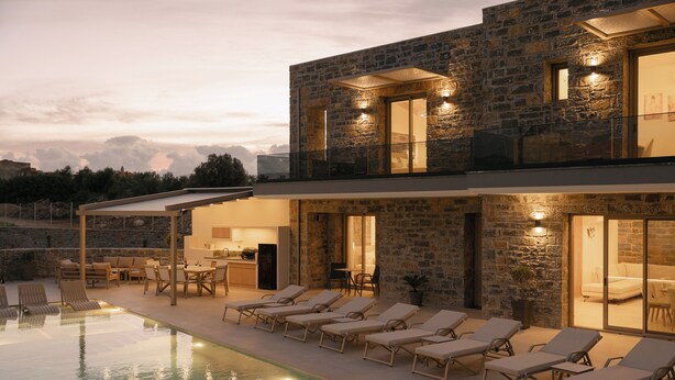 Una casa moderna con piscina, sillones de descanso y fachada de piedra.
