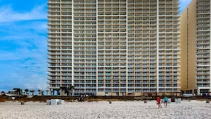 Un hotel alt amb nombrosos balcons, situat a prop d'una platja.