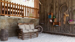 A rustic outdoor seating area with a wooden bench, a wheelbarrow, and a wooden fence. - Agriturismo Palaia - Le Botti Spacious Apartment in Farmhouse with Pool (Pelago)