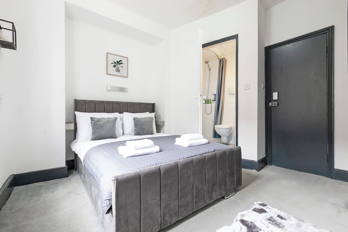 Ein Schlafzimmer mit Bett, Dusche und Tür.