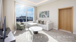 Ein modernes Wohnzimmer mit einem weißen Sofa, einem runden Couchtisch und einem großen Fenster mit Blick auf die Stadt.