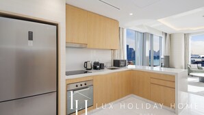 Eine moderne Küche mit Edelstahlgeräten, Holzschränken und einem großen Fenster mit Blick auf die Stadt.