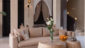 A modern interior with a beige sofa, a vase with flowers, a bowl of oranges, and a staircase. - Villa Chocolat - Private pool - Perfect for relaxed  - (7 rms/14 Gst) (Marrakech)