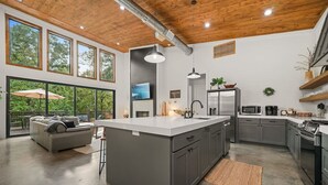 A modern kitchen with a large island, grey cabinets, and stainless steel appliances. - Hgtv Cabin- 2 Private Acres -patio Oasis Dogs OK (Broken Bow)