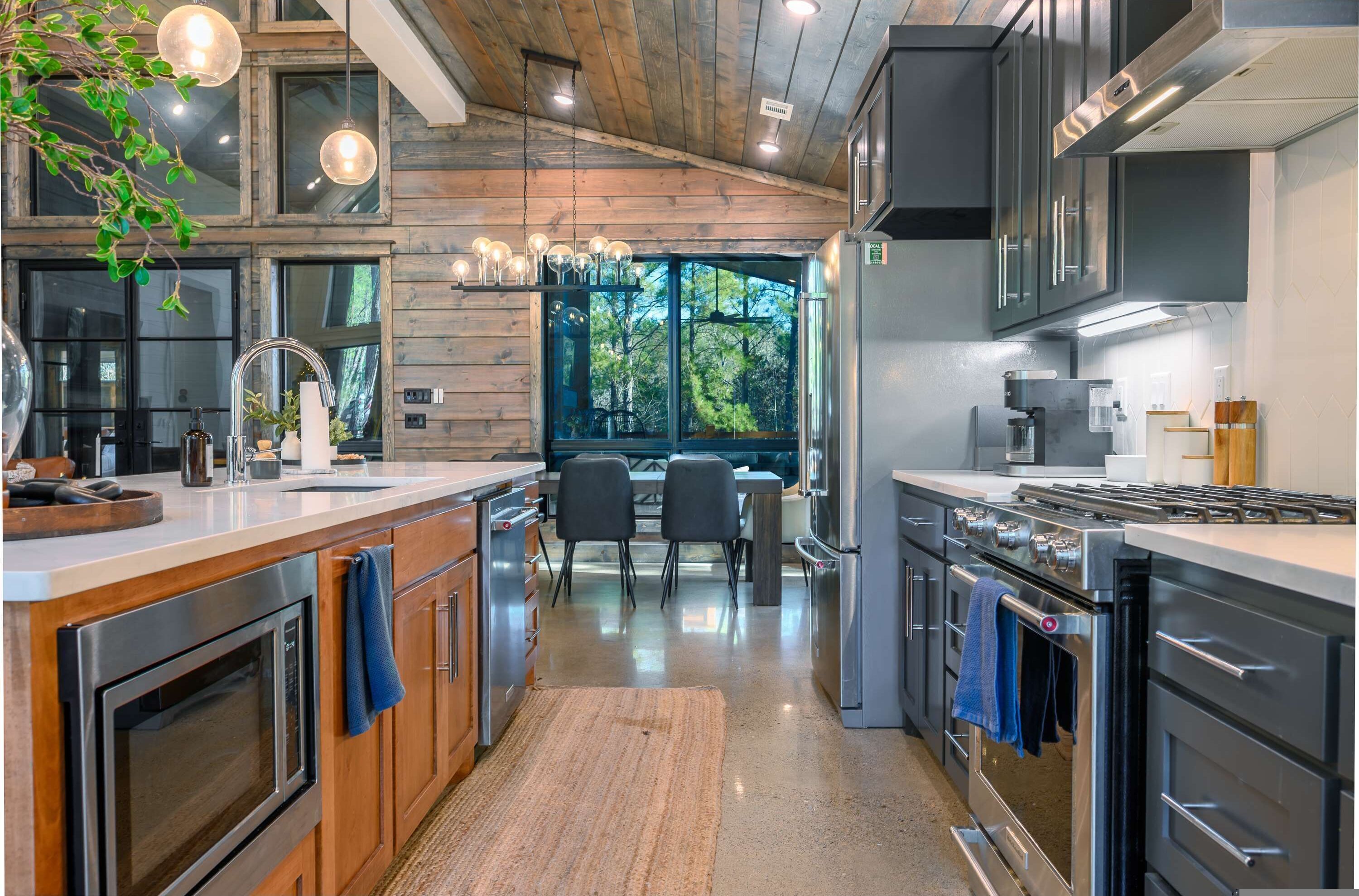 Una cocina moderna con detalles de madera, electrodomésticos de acero inoxidable y un comedor con vistas.