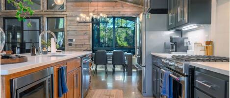 Una cocina moderna con detalles de madera, electrodomésticos de acero inoxidable y un comedor con vistas.