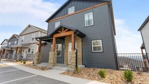 A modern two-story building with a dark exterior, stone pillars, and a covered entrance. - Modern Getaway w Hot Tub Arcade Stunning Views (Branson)
