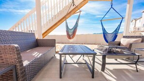 An outdoor patio with wicker furniture, a metal table, and two hammocks. - Elegant Spacious 4BR Home Peyton (Elbert)