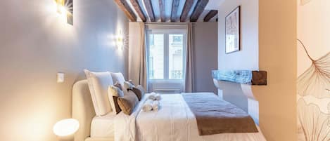 Une chambre à coucher avec un lit, des lampes de chevet, une fenêtre et une étagère fixée au mur.