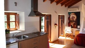 Una cocina con vigas de madera, una isla grande con un lavaplatos y un cuadro en la pared.