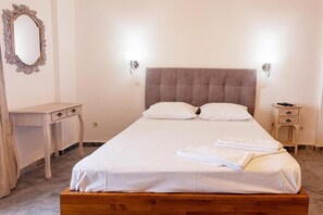 A neatly made bed with white linens, a wooden headboard, and two bedside tables with lamps. - Seaheaven House B4 - Beachfront Nest Memi Koroni (Pylos-Nestoras)