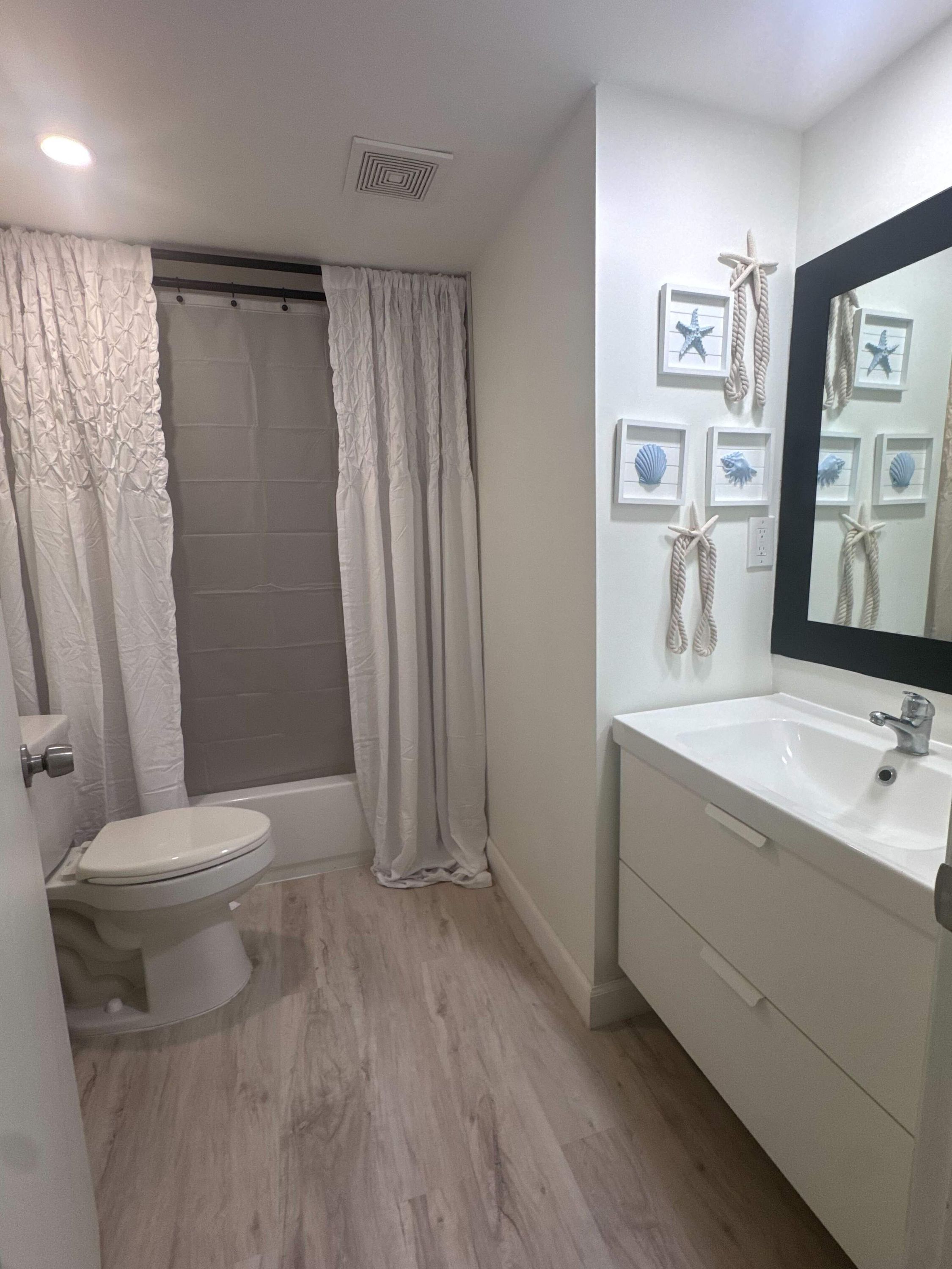 A bathroom with a toilet, bathtub, and sink.