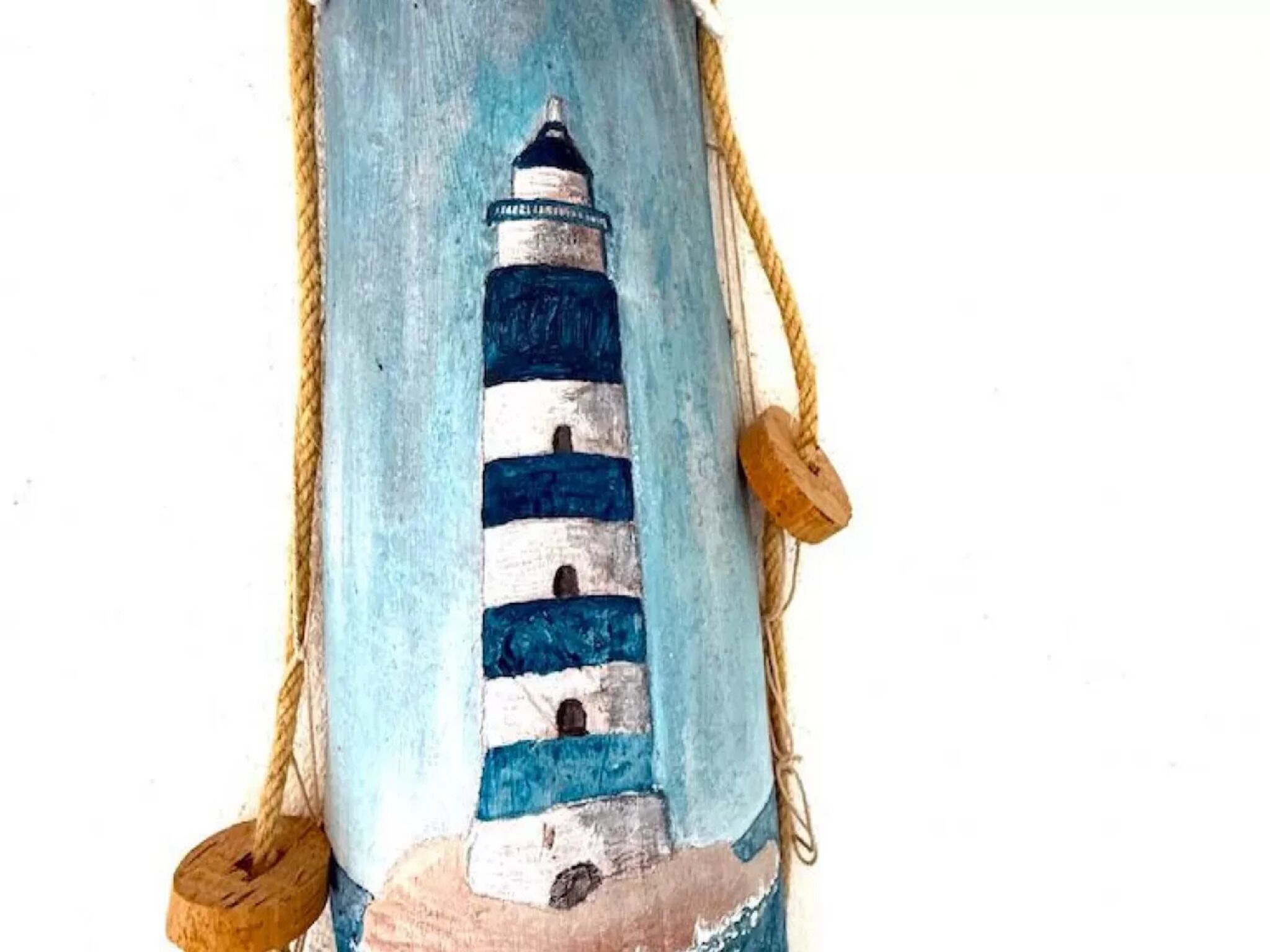 A lighthouse painted on a cylindrical object with ropes on either side.