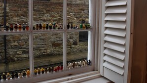 Ett skyltfönster med flera hyllor där olika LEGO-figurer visas upp.