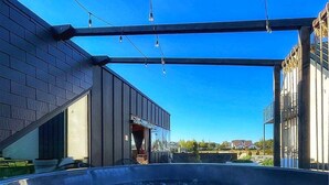 A modern building with a glass-enclosed swimming pool, a covered outdoor area, and a clear blue sky. - Awesome apartment in Ostrowo with sauna (Ostrowo)
