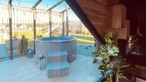 A wooden deck with a hot tub, outdoor seating, and potted plants. - Awesome apartment in Ostrowo with sauna (Ostrowo)