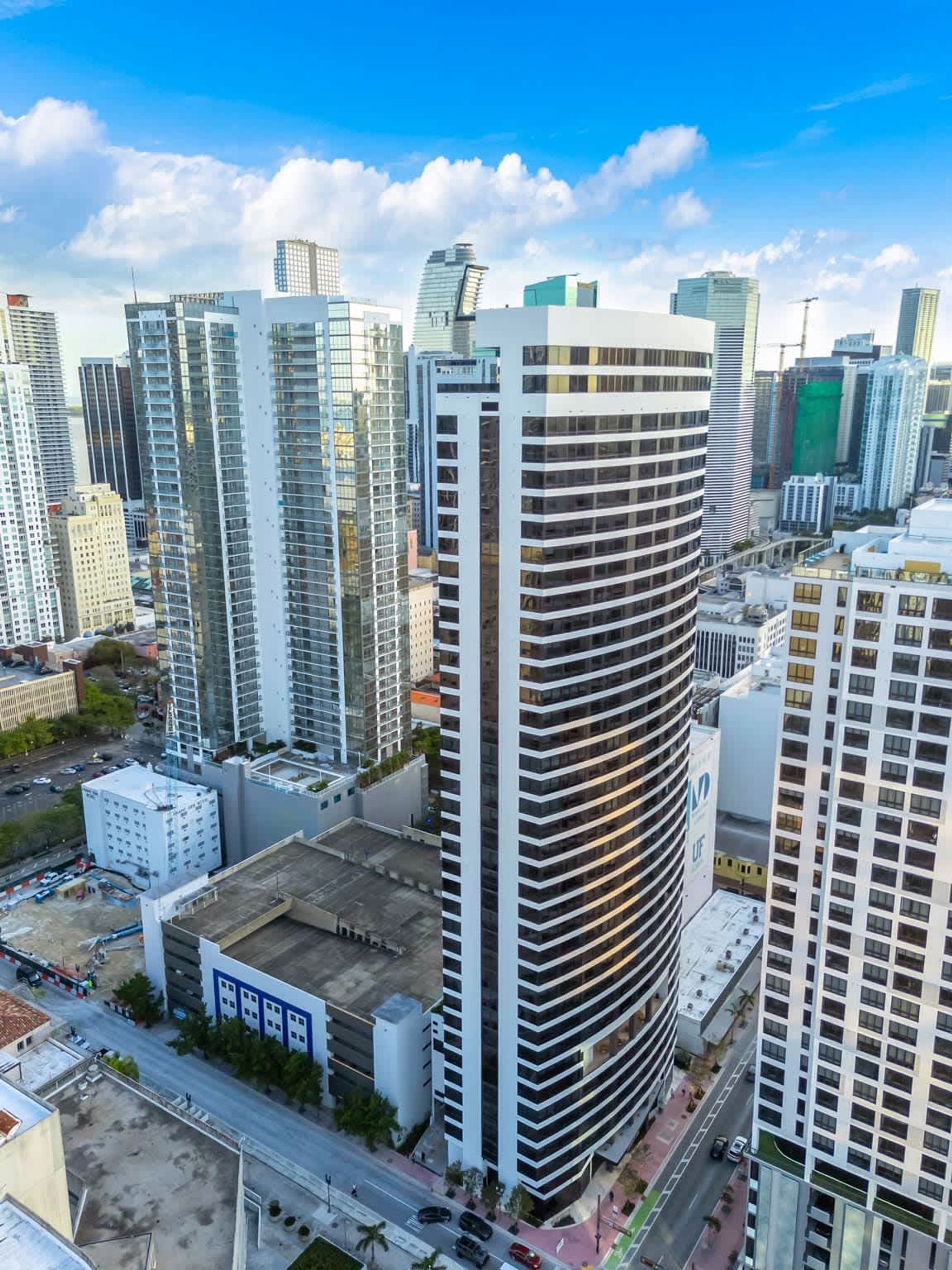 A high-rise building with a modern architectural design, featuring a curved facade and multiple balconies.