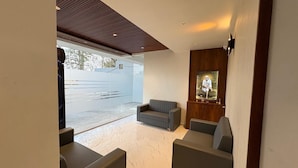 Ein modernes Interieur mit einer Couch, einem Holzschrank und einem großen Fenster.