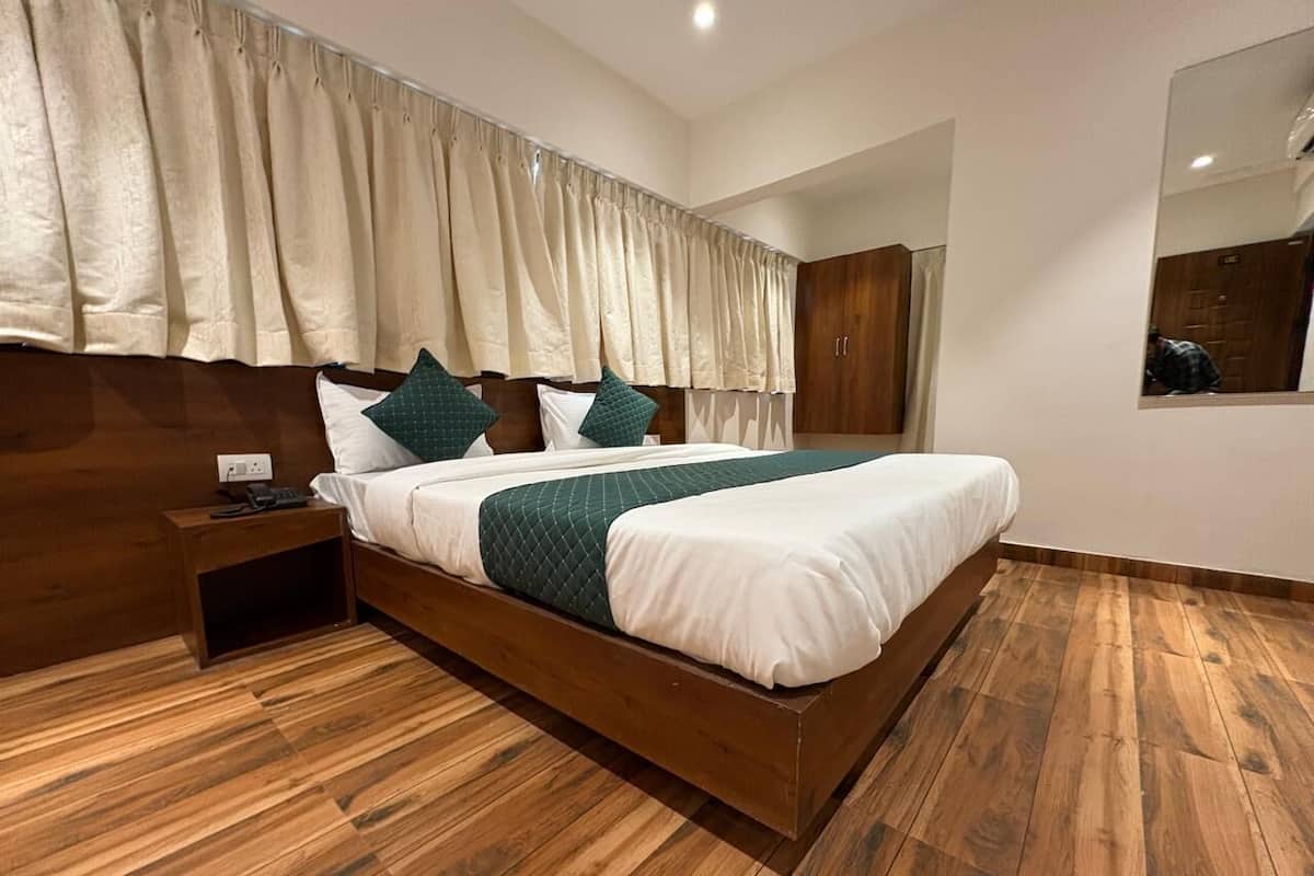 A modern bedroom with a wooden bed, a nightstand, and a large mirror.