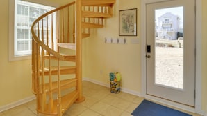 A wooden spiral staircase in a room with a door leading outside. - Rooftop Chesapeake Bay Views! Waterfront Retreat (Foster)