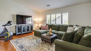A living room with a large flat-screen TV, a treadmill, a sofa set, and a patterned rug. - Fairfield Wine Country Getaway w/ Backyard Oasis! (Fairfield)