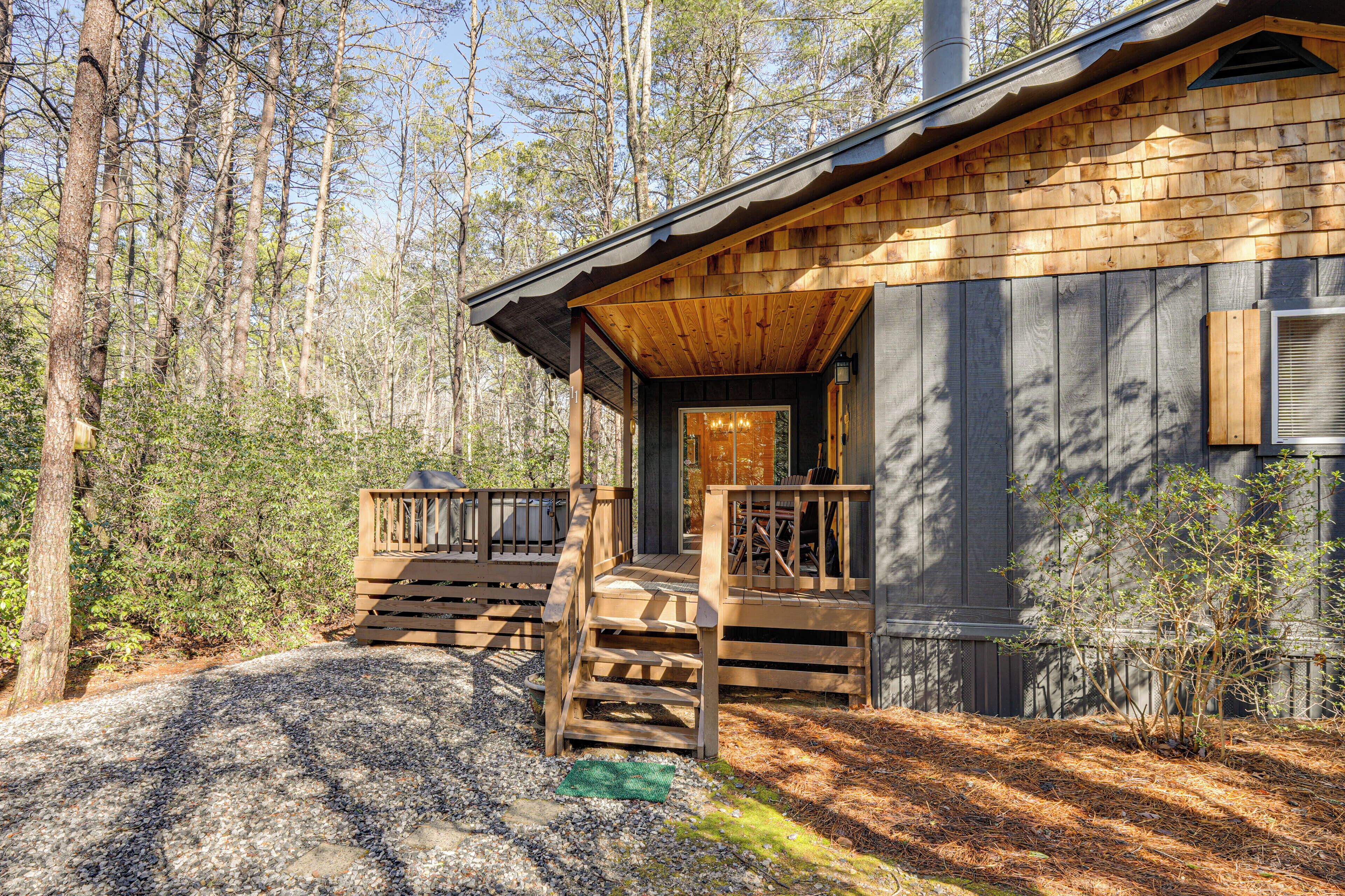 A cabin with a wooden exterior, a porch with steps, and a door leading to the interior.
