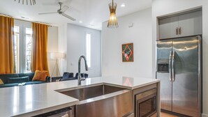 A modern kitchen with a stainless steel refrigerator, a built-in oven, and a large island with a sink. - 1 Mi to Nashville General: Upscale Townhome (Nashville)