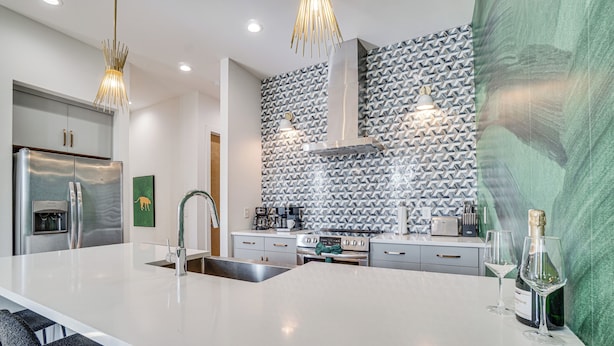 A modern kitchen with a large island, stainless steel appliances, and patterned backsplash. - 1 Mi to Nashville General: Upscale Townhome (Nashville)