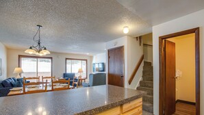 A kitchen with granite countertops, wooden cabinets, and a dining area with a table and chairs. - Pool & Hot Tub! Hub for All-season Winter Park Fun (Winter Park)