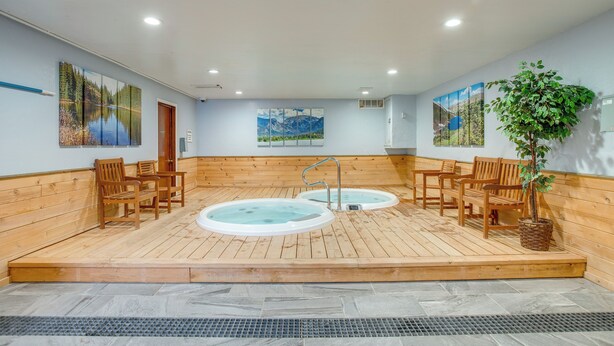 A sauna room with wooden benches, two hot tubs, and wall art. - Pool & Hot Tub! Hub for All-season Winter Park Fun (Winter Park)