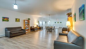 A spacious living room with a sofa, a dining table, and a bookshelf. - Pool & Hot Tub! Hub for All-season Winter Park Fun (Winter Park)
