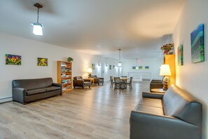 A spacious living room with a sofa, a dining table, and a bookshelf. - Pool & Hot Tub! Hub for All-season Winter Park Fun (Winter Park)