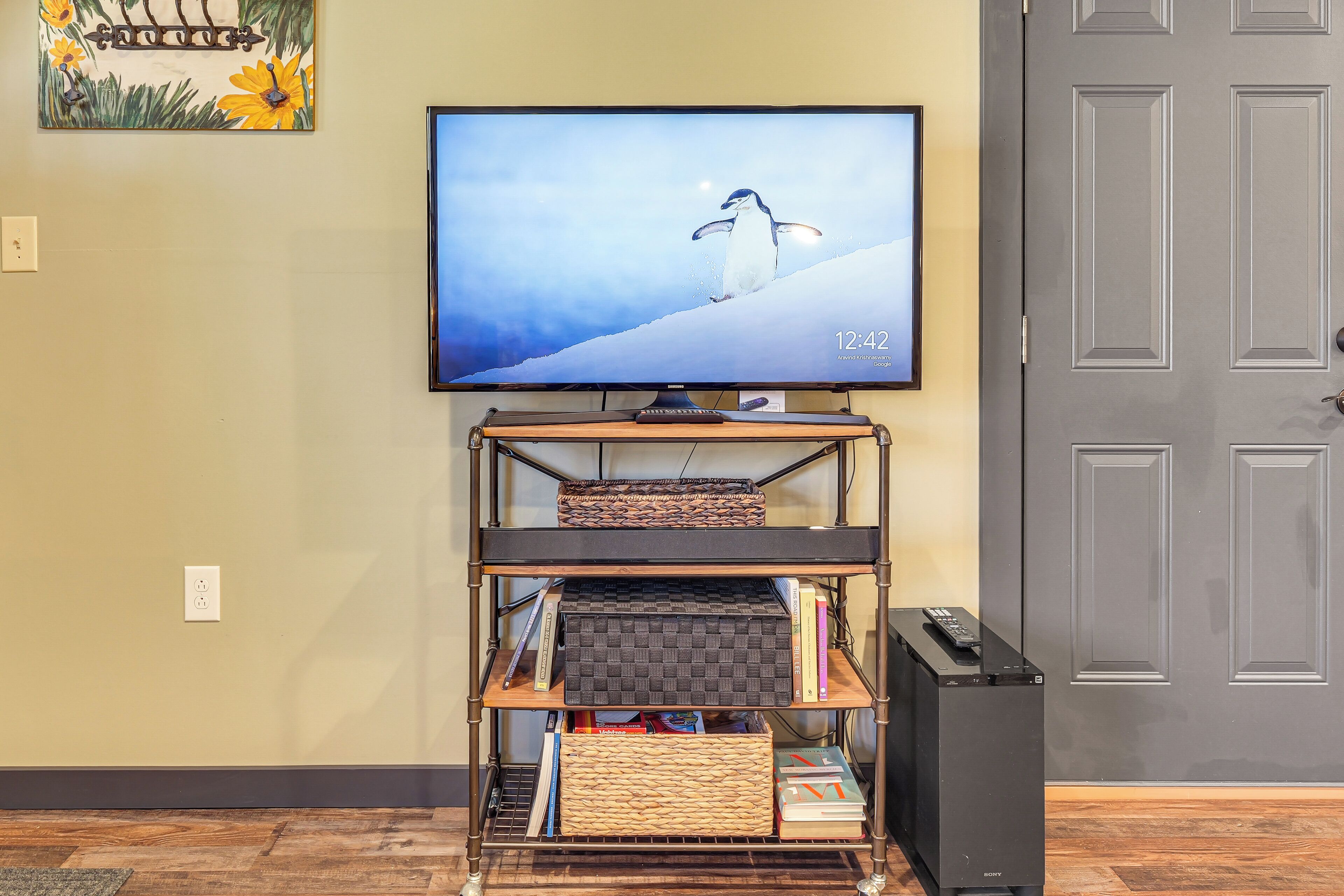 Un soggiorno con televisione su un mobile, una libreria e una porta.