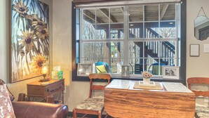 A dining area with a wooden table, chairs, and a large window with a view of a staircase and trees. - Private Patio! Studio 10 Mi to Dtwn Clarksville (Clarksville)