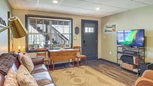 A living room with a leather couch, a dining table, and a TV on a stand. - Private Patio! Studio 10 Mi to Dtwn Clarksville (Clarksville)