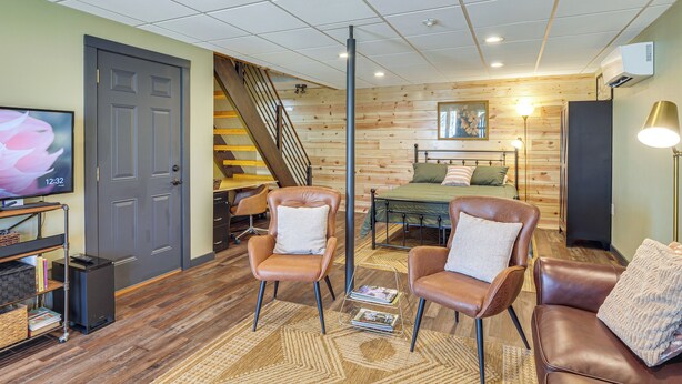 A cozy living room with a wooden floor, leather chairs, a bed, and a TV on a stand. - Private Patio! Studio 10 Mi to Dtwn Clarksville (Clarksville)