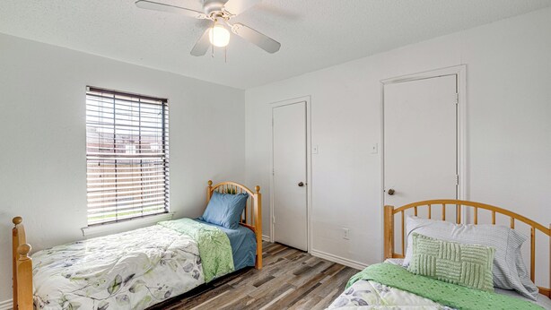 A bedroom with two wooden beds, a ceiling fan, and a window with blinds. - Explore the City w/ Ease! Quiet East Dallas Base (Dallas)