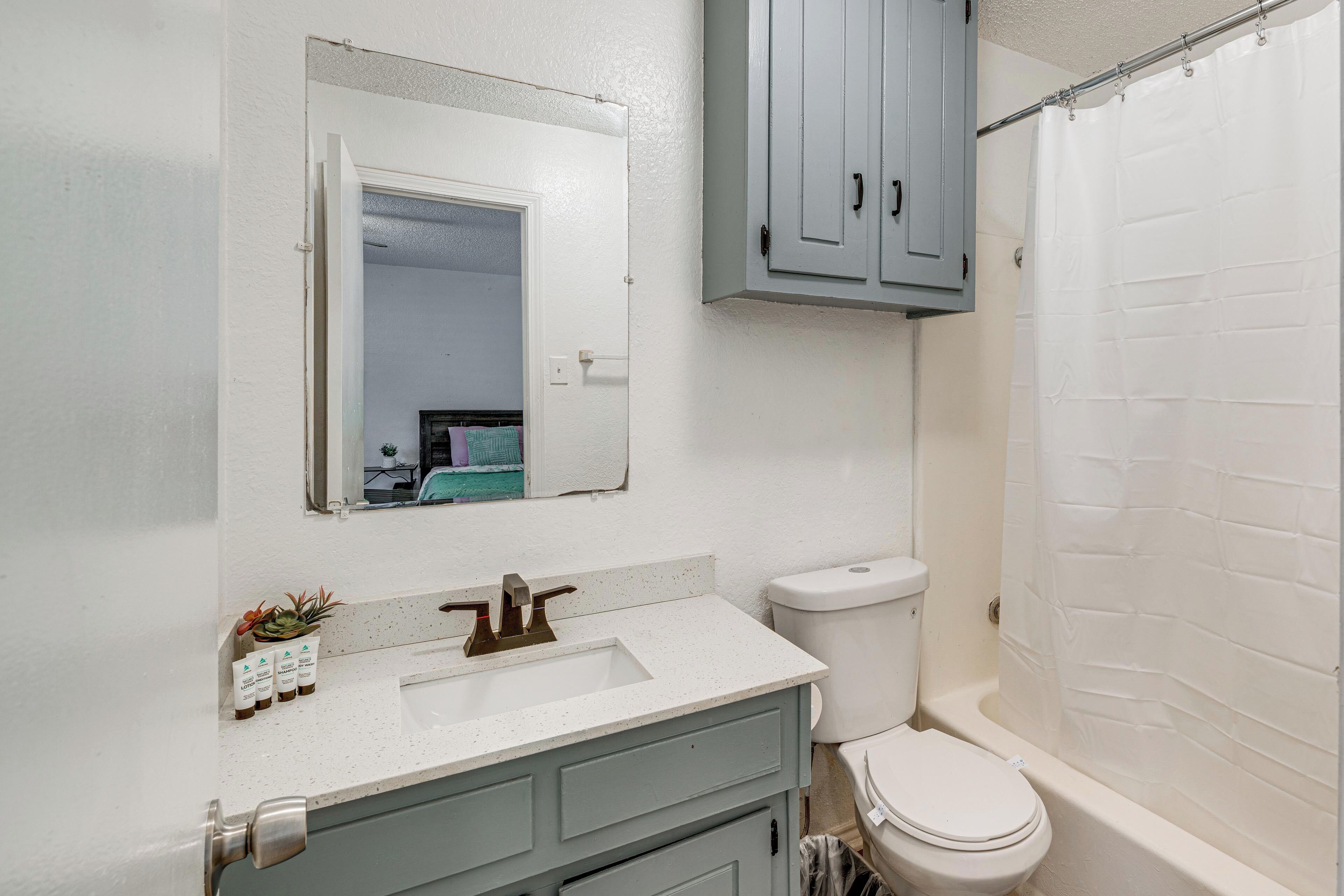 A bathroom with a white sink, a toilet, and a bathtub.