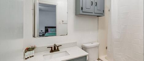 A bathroom with a white sink, a toilet, and a bathtub.
