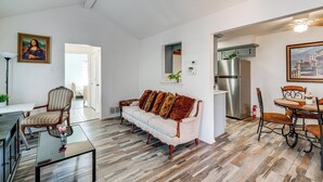A living room with a sofa, a dining table with chairs, a coffee table, and a painting on the wall. - Explore the City w/ Ease! Quiet East Dallas Base (Dallas)